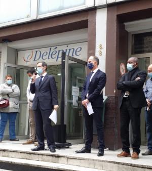 Le personnel et les dirigeants du CFA Delépine sur les marches de l'établissement, lisant leur lettre aux apprentis.