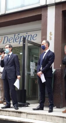 Le personnel et les dirigeants du CFA Delépine sur les marches de l'établissement, lisant leur lettre aux apprentis.